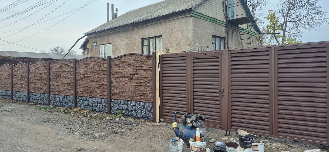 Коричневый еврозабор под камень рядом с металлическими жалюзийными воротами